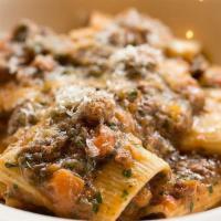 Paccheri alla Genovese · Torchio pasta with a slow-cooked, 8-hour braised sweet onion and flank steak ragu.