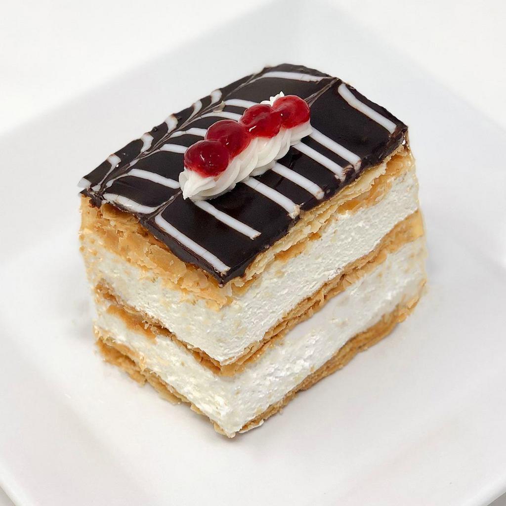 Napoleon Treat · Stacks of flakey puff pastry layered between French pastry cream and topped with chocolate ganache.