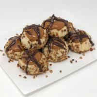 Turtle Thumbprint Cookie · Shortbread cookie with caramel center, pecans on the sides and chocolate drizzled on top.