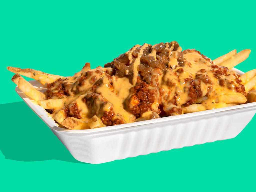 THE SHOP CHILI CHEESE FRIES · Step up your fry game with Impossible™ Chili & plant-based cheese sauce-smothered fries with chipotle crema & scallions.