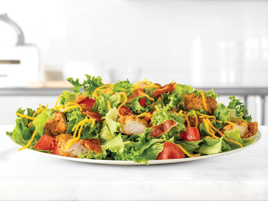 Crispy Chicken Farmhouse Salad · True, this is a salad. But don't give up on it yet. This salad is topped with meat! Not only is it piled high with crispy chicken, it has a layer of diced pepper bacon. It also comes with the usual salad stuff like chopped fresh lettuce, diced tomatoes and shredded cheddar cheese.