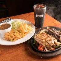 Sizzling Fajitas · Served with caramelized onions, bell peppers, rice, beans, and all the fixings.