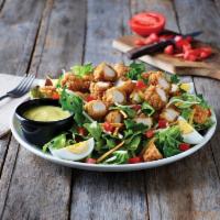 Crispy Chicken Tender Salad · A hearty salad with crispy chicken tenders on a bed of fresh greens topped with a blend of C...