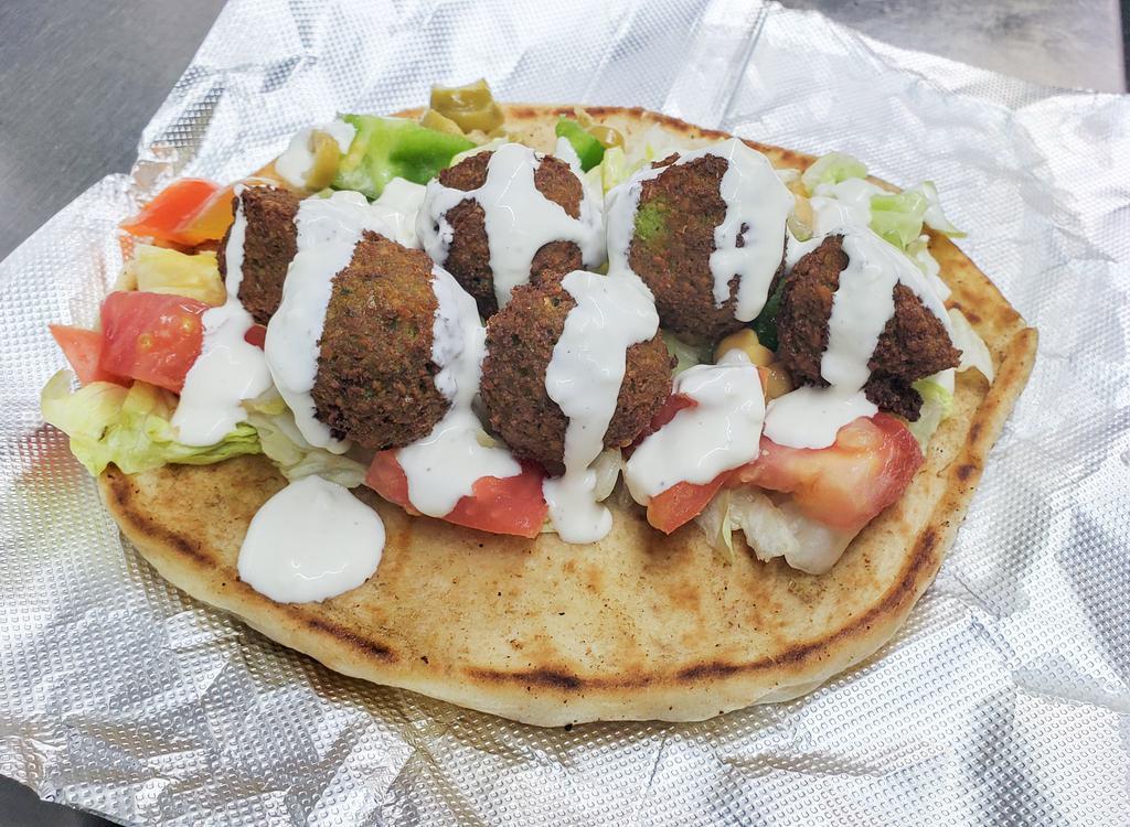 Falafel Sandwich · A mix of ground chickpeas, fava beans, and fresh herbs, deep-fried and served on pita with lettuce, tomatoes, onions, pickles, olives, and tahini sauce.