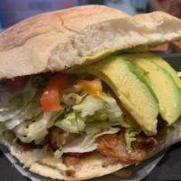 Colita de Pavo Torta · Mexican bread roll, spread with mayo, and avocado, filled with turkey tail, lettuce, and tom...