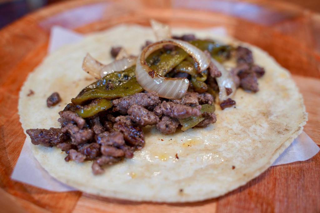 Guanajuato Taco · Sirloin steak, grilled onions and green chili over handmade corn tortilla. Sirloin steak a la plancha, cebolla y chile California asados sobre tortilla de maiz hecha a mano. 