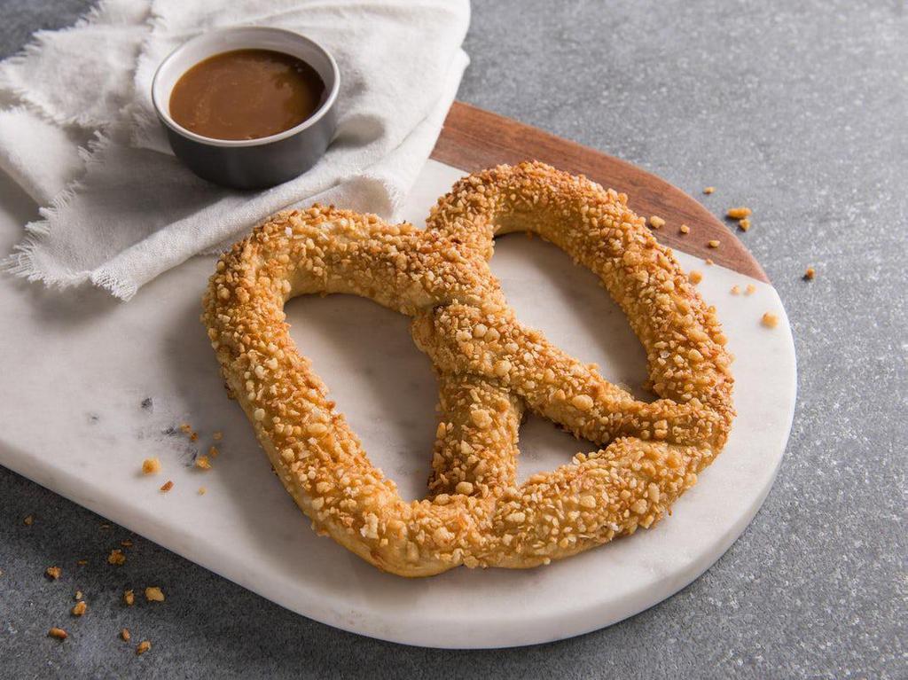 Sweet Almond Pretzel · A sweet yet salty pretzel baked fresh and topped with our own toasted almond crunch. Pair it with a Caramel dip to enjoy a favorite combination of our founder, 