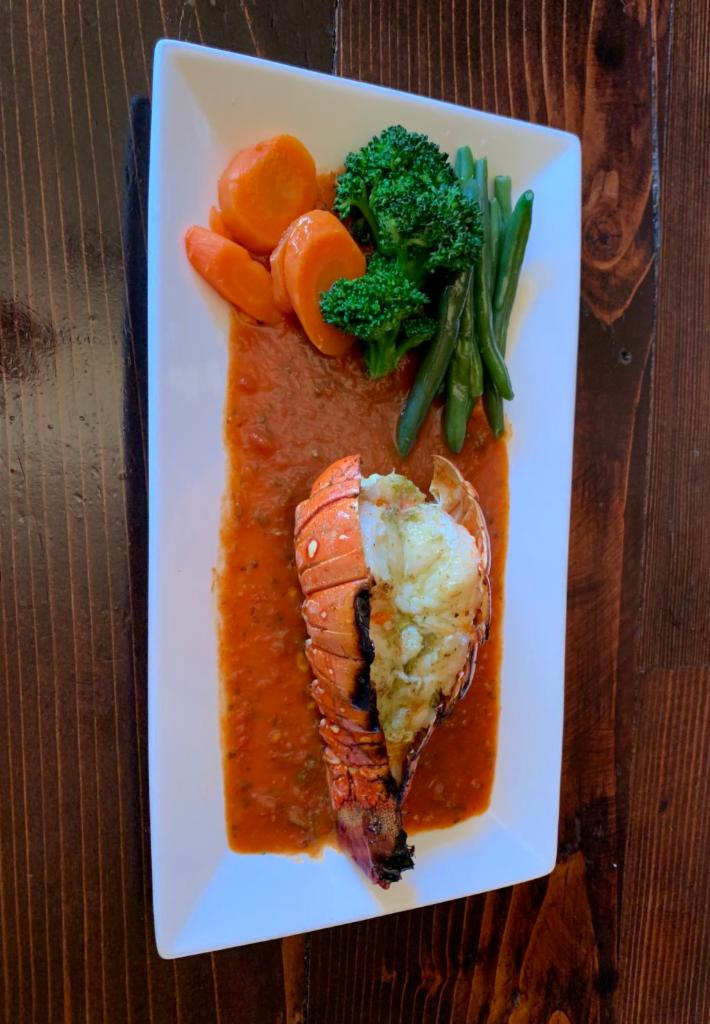 Grilled Lobster Tail/Cola de Langosta a la Parrilla  · Delicious Grilled lobster tail served in marinara or seafood sauce. Accompanied with side of choice