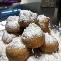 Funnel Cake Donut · Donuts covered in powdered sugar.

