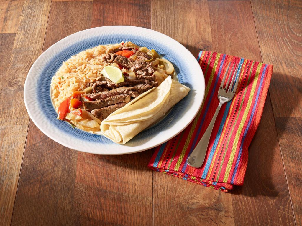 Steak Fajitas · Piled high on a sizzling skillet with sauteed onions and peppers, guacamole, cheese, pico de gallo, sour cream, warm flour tortillas, Spanish rice and choice of beans. 
