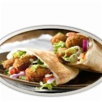 Falafel sandwich on pita or as tortilla wrap  · Vegetarian option made of chickpeas, onions, scallions, and garlic, ground and mixed with Me...