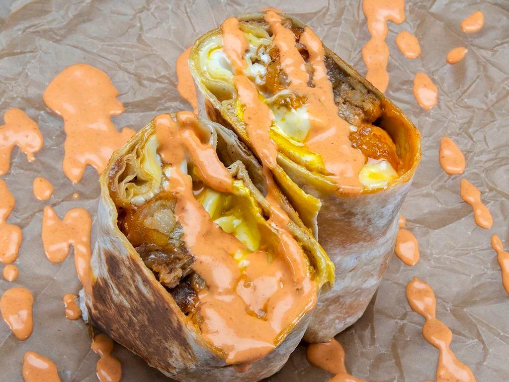 Würst Burrito · 3 eggs, choice of haus sausage, white American cheese, crispy tater tots, caramelized onions, spicy mayo; sides of spicy mayo & hot sauce.