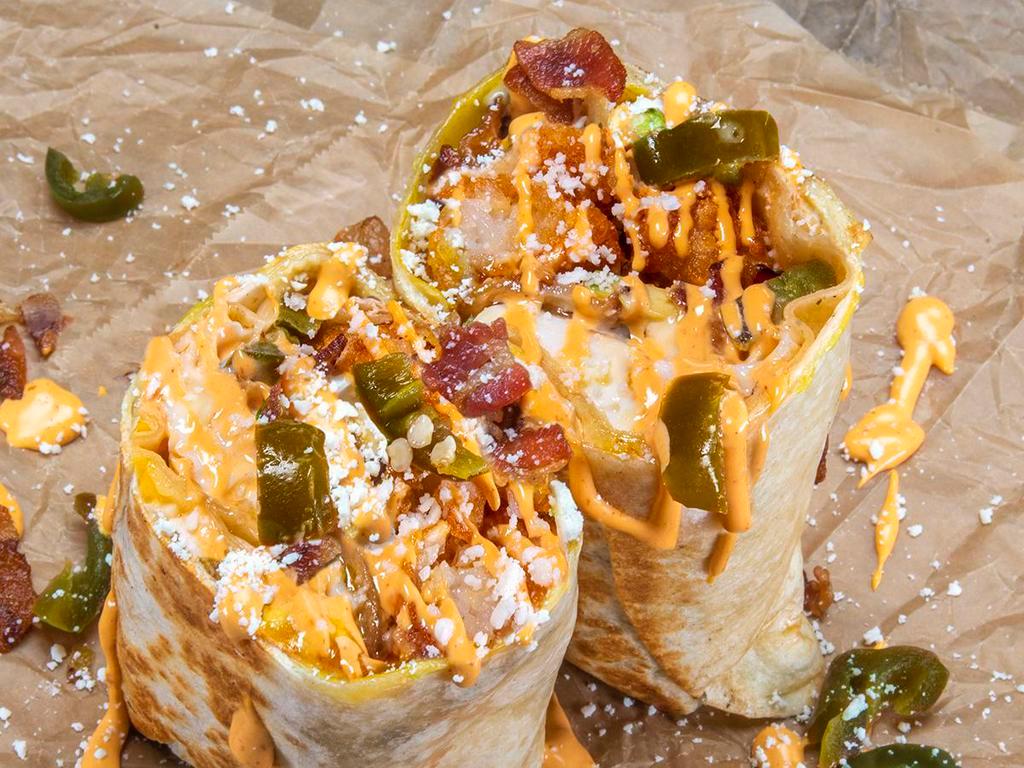 Bronco Burrito · 3 eggs, smoked bacon, white American cheese, avocado, pickled jalapeños, crispy tater tots, cotija cheese, chipotle aioli; sides of chipotle aioli & hot sauce.
