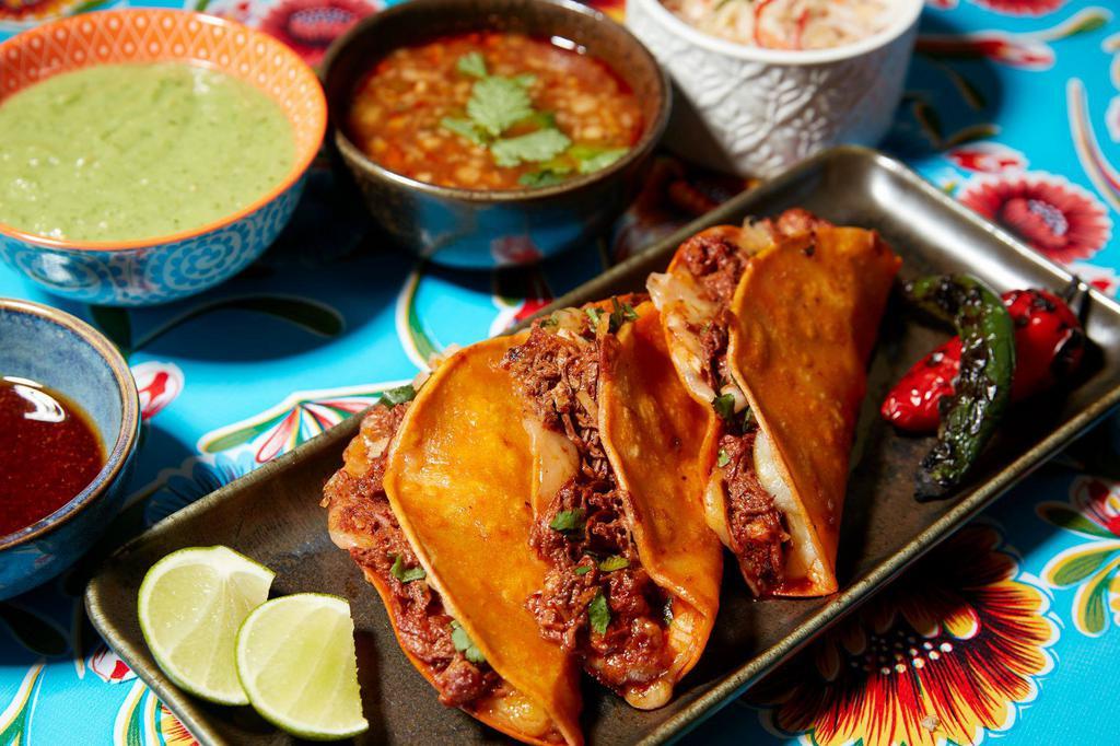 Quesabirrias  · Three dipped and griddled corn tortillas stuffed with cheese, onions, cilantro, original braised beef birria.  Served with a sides of consome, pickled cabbage slaw, salsa verde, chile oil and lime.

gf