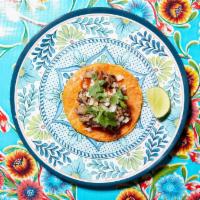 Beef Birria Taco · Prime beef short rib braised in mild red chile broth. Topped with onions, cilantro, & Suavec...