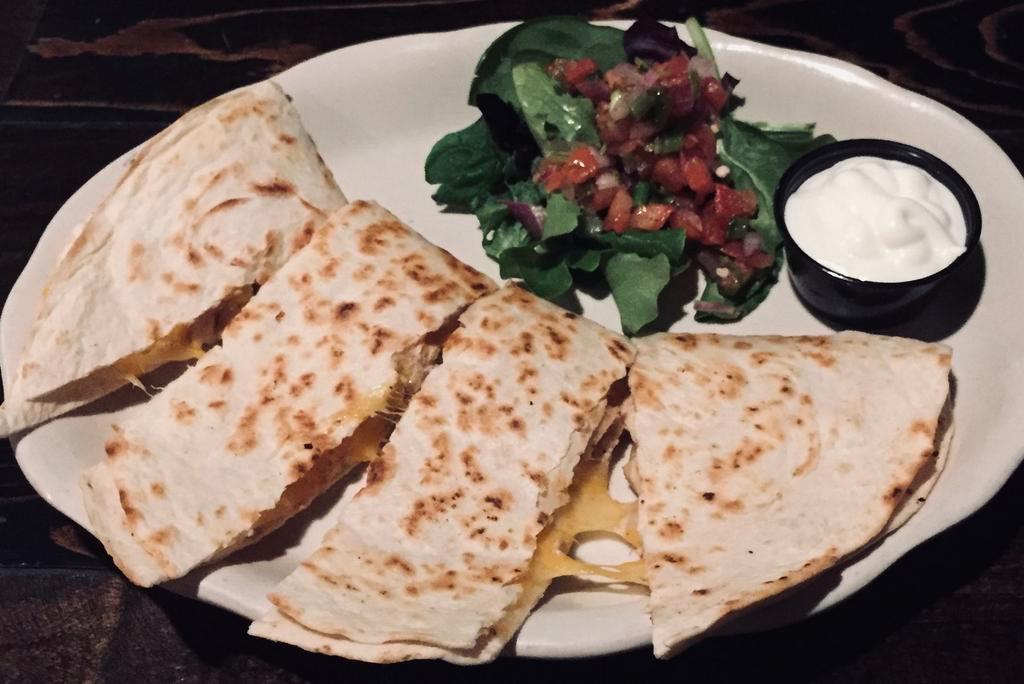 Quesadillas · Flour tortilla, caramelized onions, mozzarella cheese, sour cream, and salsa. Enhance with grilled chicken or steak for an additional charge.