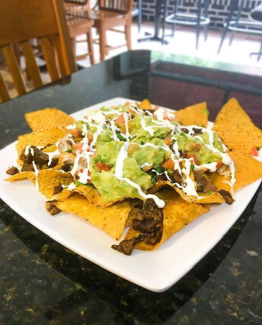 Nachos · Nacho cheese, beans, sour cream, guacamole and jalapenos. Choice of meat: pork, chicken, or ground beef, steak for an additional charge.