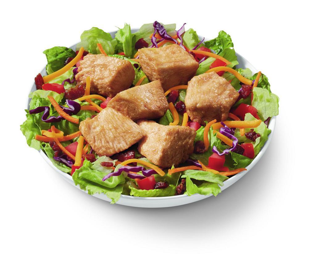 Rotisserie-style Chicken Bites Salad Bowl · DQ's new 100% white meat, juicy tender, rotisserie-style chicken bites, served on top of a crisp bed of lettuce, diced tomatoes, bacon and shredded cheddar. Served with house-made Hidden Valley Ranch, or your choice of dressing.