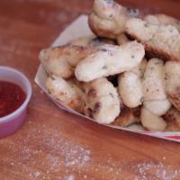 Garlic Knots · Breadsticks all tied up and smothered in buttery garlic sauce, then rolled in Parmesan chees...