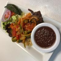 Bistec Encebollado Plate · Steak in sauteed onions, green peppers, and tomatoes, salad rice beans