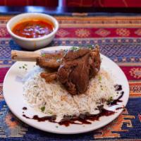 Kuzi · Lamb shank cooked with tomato sauce, onion, salt, cinnamon, garlic. Served with a flavored r...