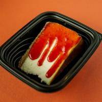 New York Style Cheesecake · Traditional graham cracker crust cheesecake with strawberry sauce.
