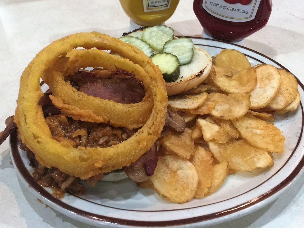 Tavern Burger · 2 all beef patties topped with our house made BBQ pulled pork, melted cheddar cheese, bacon, pickle, fried onion rings and apple wood smoked BBQ sauce served on a grilled bun. Served with our homemade deep fried chips.