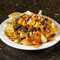 Supreme Nachos · House made nacho cheese sauce, shredded cheese, pickled jalapenos, layered between a mound o...