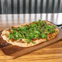 Fig & Prosciutto Flatbread · Oven Baked Flatbread with Fig Jam, Proscuitto, Manchego Cheese and Topped with Arugula Tosse...
