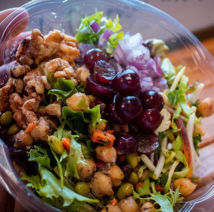 SUPER GREEN SALAD · Fresh Greens, Grapes, Cranberries, Edamame, Chickpeas, Red Onion, Walnuts, Shaved Veggies with House Made Vinaigrette