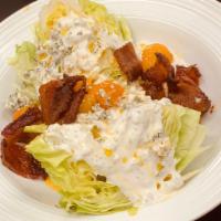 Chopped Wedge Salad · Candied bacon, chive oil, confit tomatoes, crumbled bleu cheese, bleu cheese dressing.
