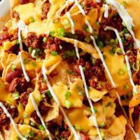 Lock and Loaded Nachos · Warm nachos topped with cheese, chili meat sauce, tomatoes, jalapeños, and sour cream.