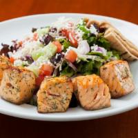 Salmon Salad · Grilled Atlantic salmon on a bed of mixed greens topped with cucumbers, tomatoes, red onions...