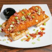 Chicken Waffle · Fresh breaded chicken tender on a waffle, maple syrup, chopped bacon and sliced green onions.
