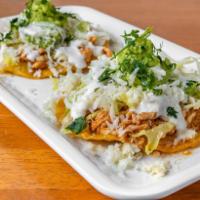 TOSTADA DE TINGA DE POLLO · (Order of  3) Chicken prepared Mexico City style,
with lettuce, cheese, cream cheese and av...