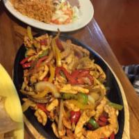 Chicken Fajitas · Our famous fajitas are served with sauteed onions, bell peppers and tomatoes on a sizzling p...