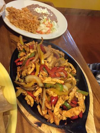 Chicken Fajitas · Our famous fajitas are served with sauteed onions, bell peppers and tomatoes on a sizzling plate. Served with lettuce, guacamole, pico de gallo, sour cream, rice, beans and tortillas.