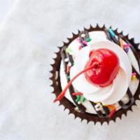 Hot Fudge Sundae Cupcake · Chocolate cake with our signature buttercream frosting, chopped peanuts, hot fudge, and a ch...