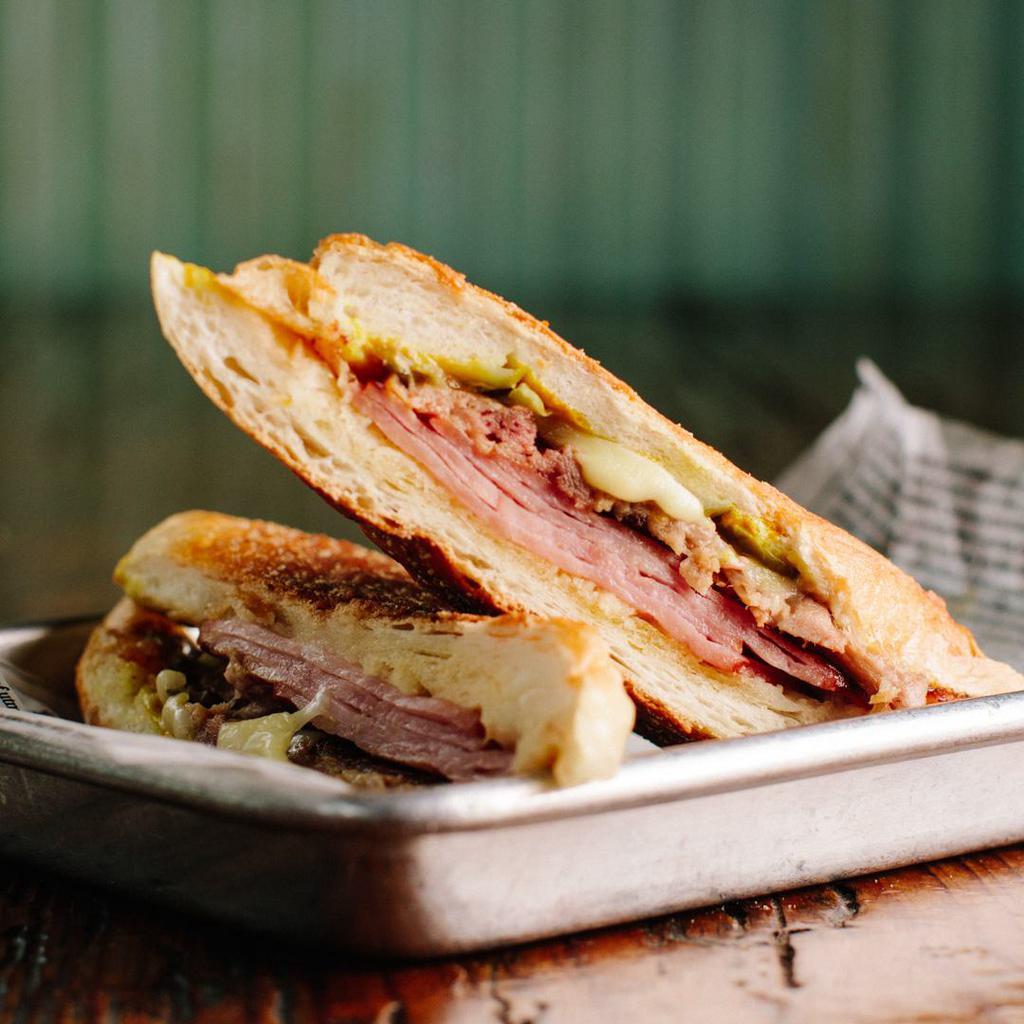 Cubano by 90 Miles Cuban Cafe · By 90 Miles Cuban Cafe. Ham, roast pork, Swiss cheese, pickle, and mustard. Contains gluten and dairy. We cannot make substitutions.