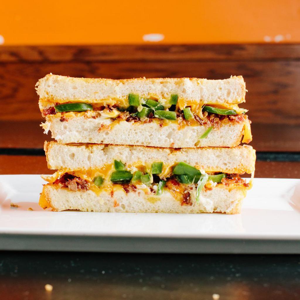 The Popper · Cheddar cheese, cream cheese, cheddar cheese sauce, fresh jalapeno slices, and bacon on sourdough. Served with a side of spicy chipotle mayo. Contains gluten, dairy, soy, and nightshades. We cannot make substitutions.
