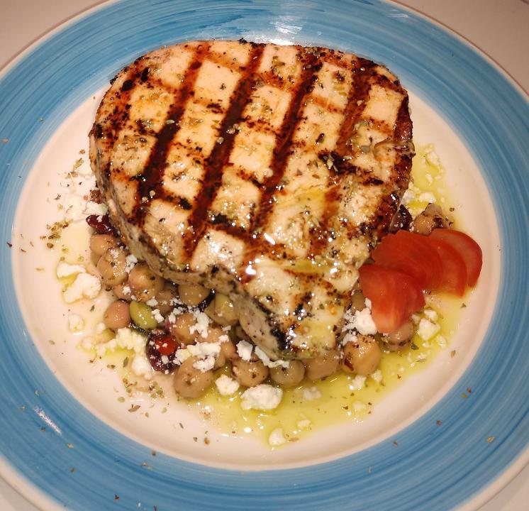 Yellow Tuna Revsi · Fresh Yellow Tuna steak seared on the charcoal grill served over a cool, fresh chickpea salad made with edamame, diced green & red peppers, carrots, cranberries, olive oil, vinegar and seasonings topped with feta cheese crumbles.