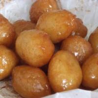 Loukoumades · Fried dumplings topped with honey syrup and cinnamon.