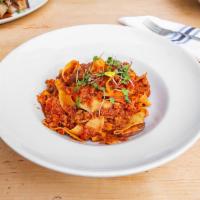 Pappardelle al Ragu e Porcini · Ribbon pasta with braised meat ragu and porcini mushrooms.