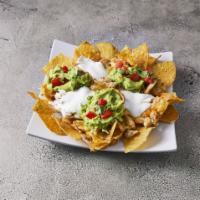Nachos con Carne · Topped with beans and melted cheese, served with sour cream and guacamole.