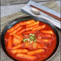 Dukbokki · Stir fried spicy rice cake topped with green oinion and sesame seeds.