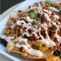 Nachito Libre - Small · Corn chips, black beans, cheddar, jalapeños, guac, sour cream, and pico de gallo.