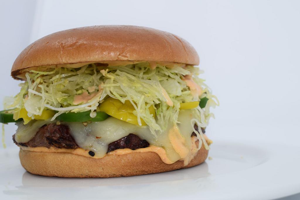 THE AZTEC BURGER · Pork Chorizo, Fresh Jalapeño Slices, Pepperoncini, Pepper Jack Cheese, Shredded Lettuce, and Chipotle Mayonnaise. 

100% fresh ground in house, 1/2 lb All-Natural chuck, flame grilled, and served on a toasted bu  with a pickle spear on the side.