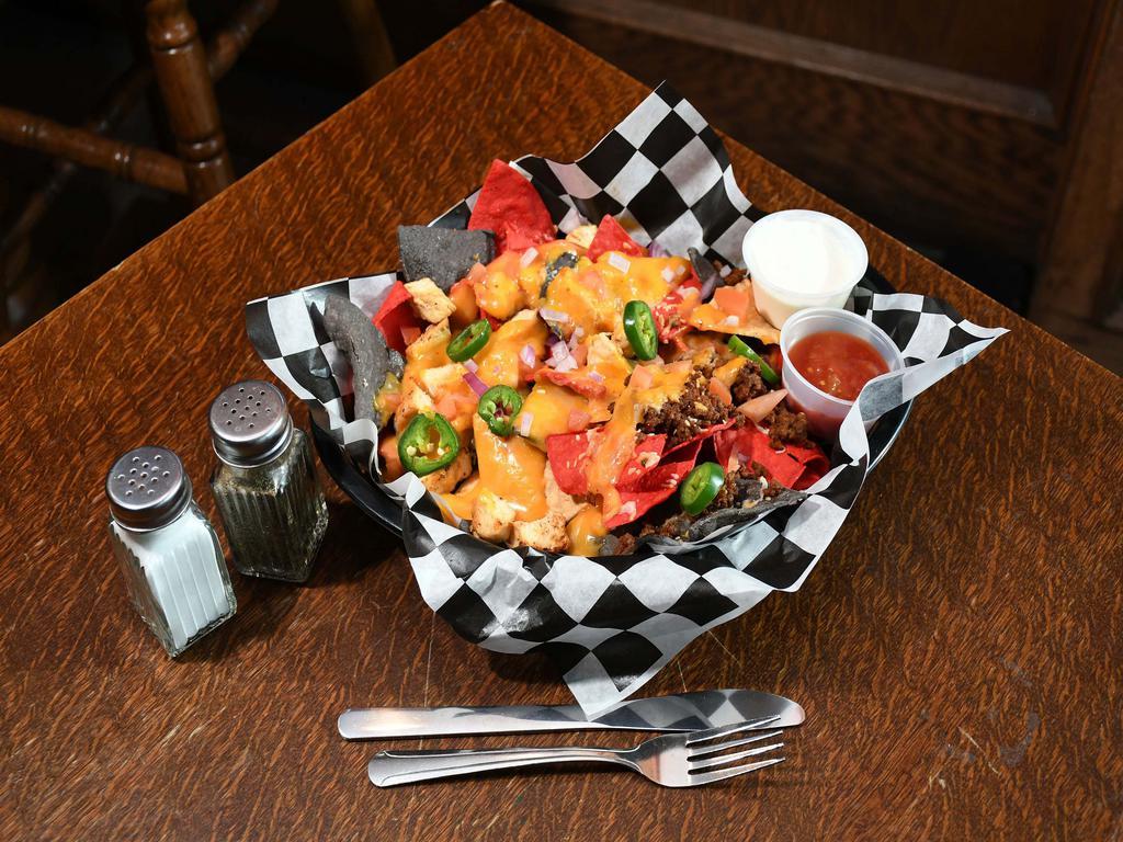 Nachos · Choose between waffle fries or tortilla chips. Served with beef, chicken or graziano sausage, house-made queso, tomato, onion, bacon bits and jalapenos. Served with sour cream and salsa.
