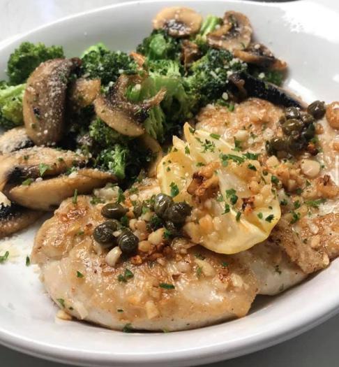 Chicken Picatta · Chicken breast smothered in a tangy white wine butter sauce, lemon juice studded with capers and served with mixed veggies.