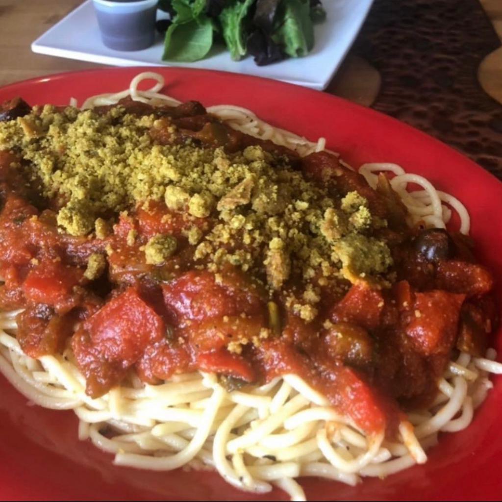 Creole Spaghetti · Olive oil glazed semolina pasta served with house-made spaghetti sauce starring tomatoes, peppers, onions, garlic, black olives, topped with our house made vegan crumbles served with our fresh Baked bread .